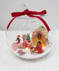 Pomme de Noel décorée avec une maison de pain d'épices vue de face avec bébé fille et garçon guirlande led gourmandises de Noel