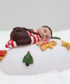 Veilleuse galet lumineuse sur lequel est posé un petit bohomme de Noel avec des décos festives. aux couleurs de Noël.