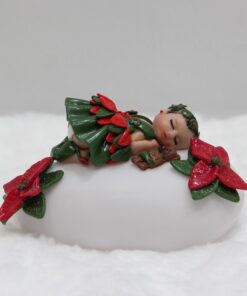 veilleuse galet lumineuse multi colore sur lelquel repose une petite fille endormi habillée en fleur de Noël.